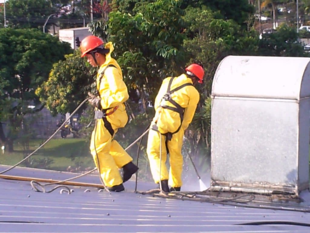 Equipe ROTEC com EPI fazendo hidrojateamento em cobertura